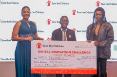 Evaline Momanyi, hands over a dummy cheque to the winner of Save the Children’s Digital Innovation Challenge, Mack Muthomi (C) and his colleague Alex Mwaniki. PHOTO/COURTESY