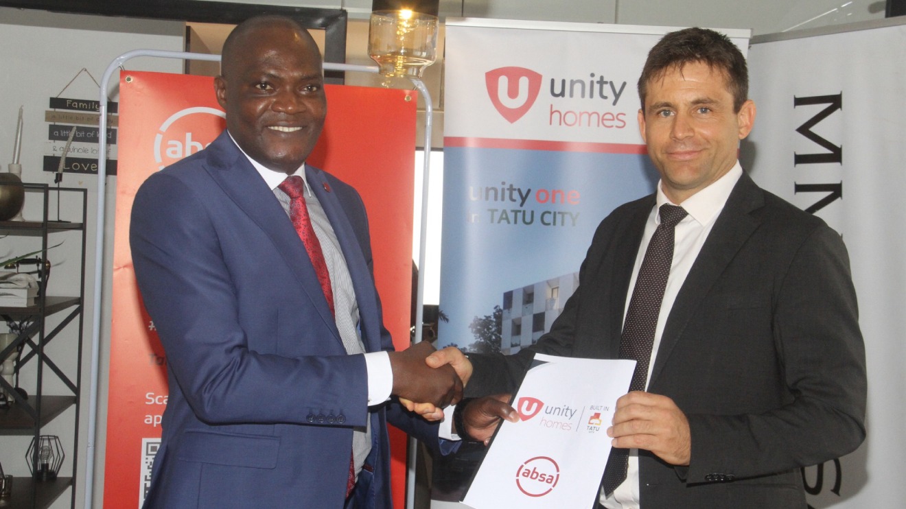Representatives from ABSA and Unity Homes shake hands after signing the partnership. PHOTO/COURTESY