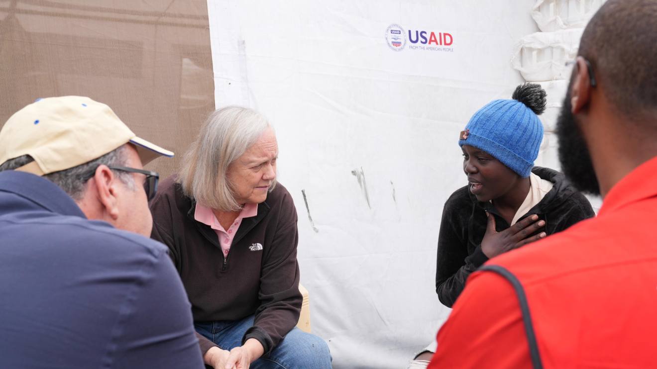Meg Whitman accompanied by Kenya Red Cross officials speaking to a victim of the floods. PHOTO/COURTESY