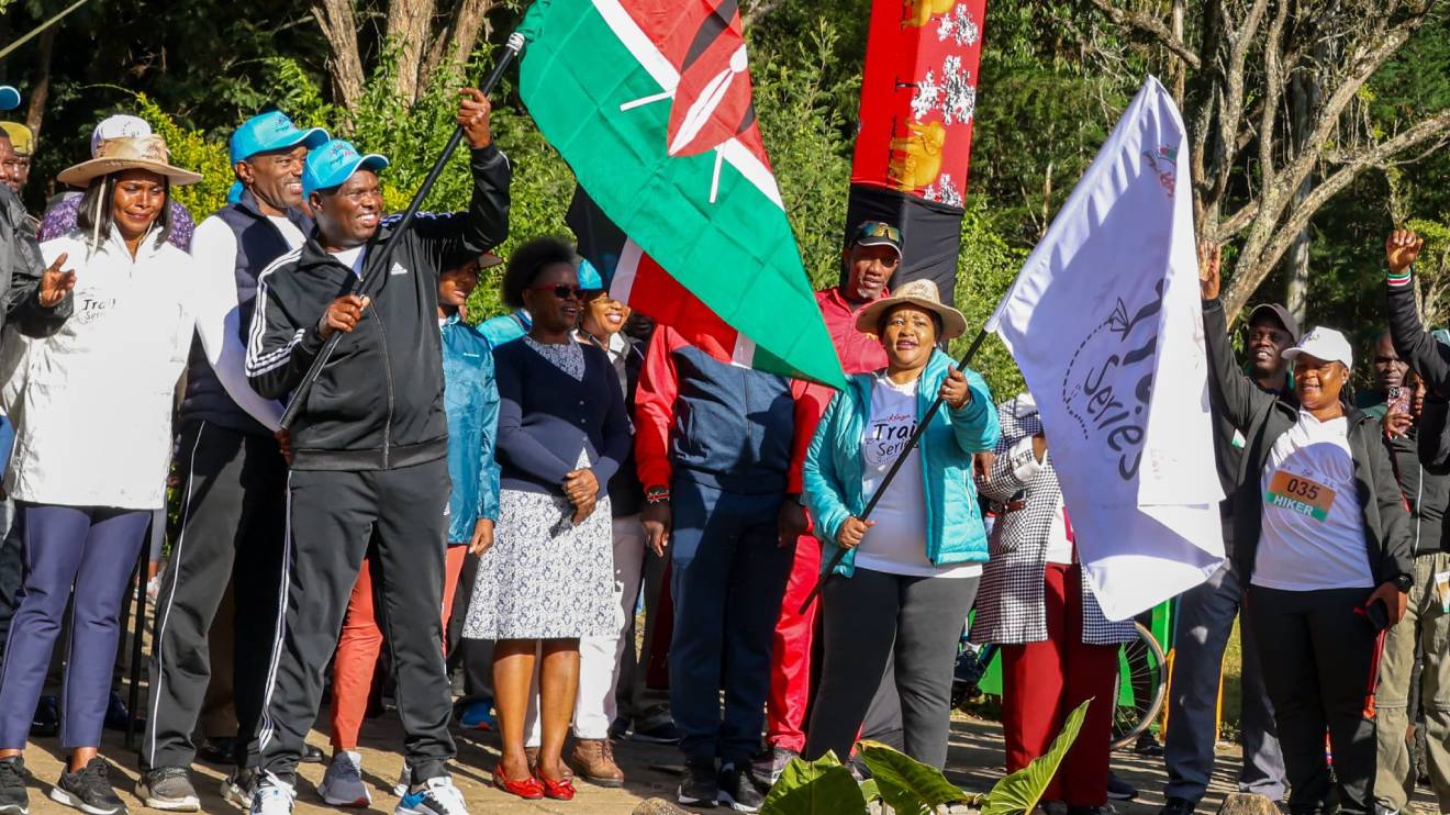 Felix Koskei (with the Kenyan flag) and Rebecca Miano (with the Trail Series flag). PHOTO/COURTESY